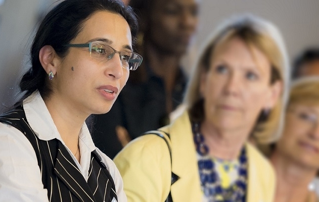 Frances Contreras talks to a group of faculty. She is the only person in focus in the photograph